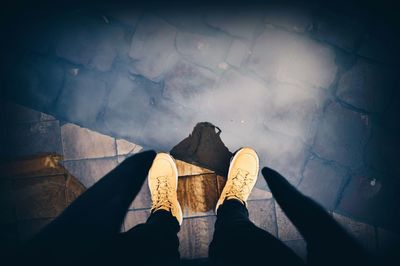 Low section of man standing on puddle with reflection