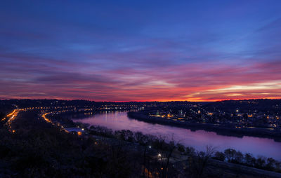 Aerial view of illuminated city against sky at sunset