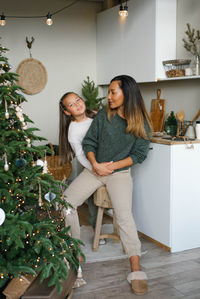 Happy mom and daughter have fun while waiting for christmas in the kitchen
