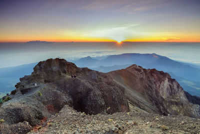 People on summit mount rinjani at sunset