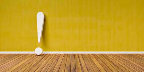 Close-up of empty table against yellow wall