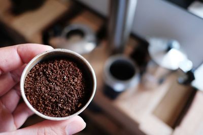 Coffee maker preparing to blend coffee beans and put ground coffee to moka pot.