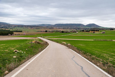 Empty country road through fields on a cloudy spring day. alcarria region, guadalajara, spain