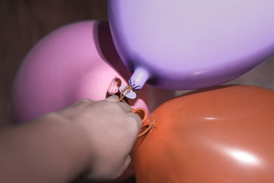 Close-up of hand holding multi colored balloons
