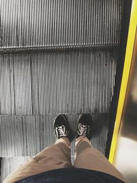 Low section of man standing on tiled floor
