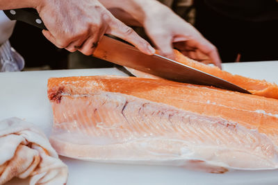 Close-up of man holding fish on table