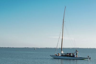 Sailboats sailing in sea against sky