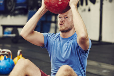 Man training in gym with medicine ball