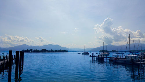 Scenic view of wooden posts in sea against sky