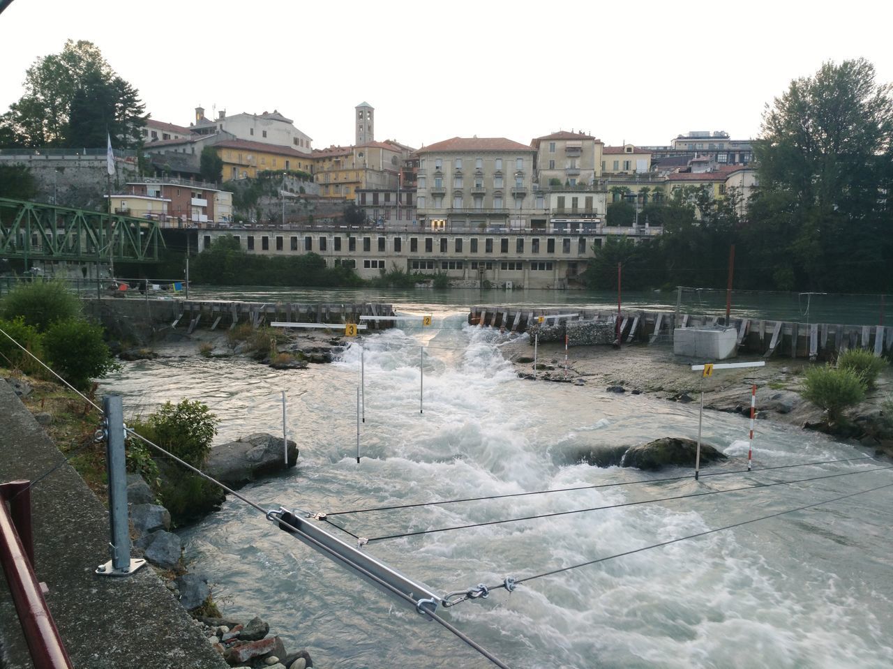 RIVER BY BUILDINGS IN CITY AGAINST SKY