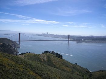 Scenic view of suspension bridge over sea against sky