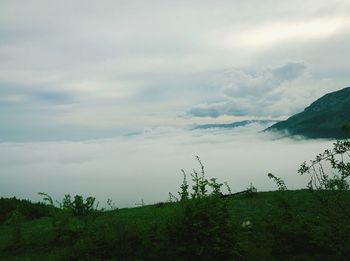 Scenic view of mountains against cloudy sky