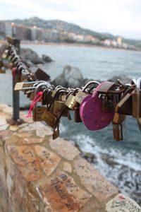 Close-up of padlocks on railing against river