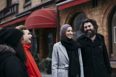 Group of friends walking on street and laughing