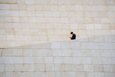 Rear view of man walking on wall