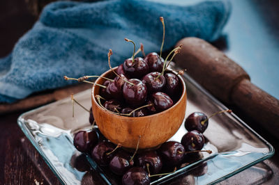 Close-up of cherry fruits in a wooden bowl on table