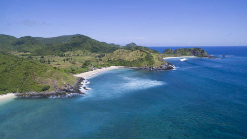 Scenic view of sea and mountains against clear blue sky