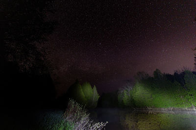 Scenic view of lake against sky at night