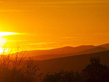 Scenic view of landscape against orange sky