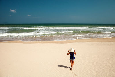 Full length of woman on beach against sky