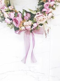 Close-up of pink roses against white wall