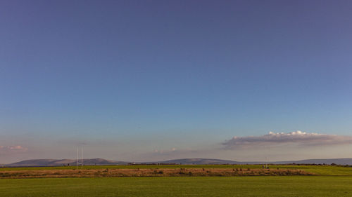 Scenic view of field against blue sky