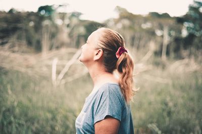 Girl looking away while standing on field
