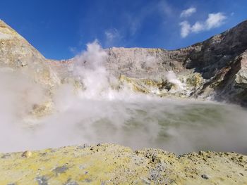 Scenic view of waterfall against sky