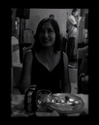 Portrait of a smiling young woman sitting at restaurant