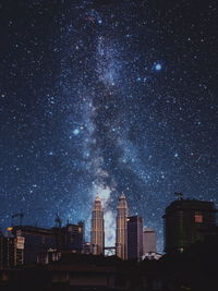 Low angle view of illuminated buildings against sky at night