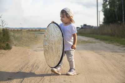 A toddler holds a reflector for the photographer. little helper assistant