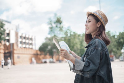 Young woman using mobile phone in city