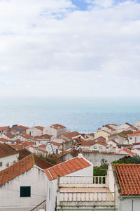 High angle view of townscape by sea against sky