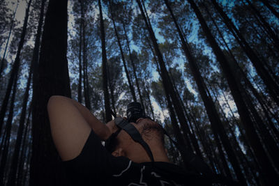 Man photographing trees in forest