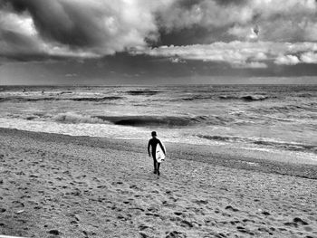 Scenic view of beach against cloudy sky
