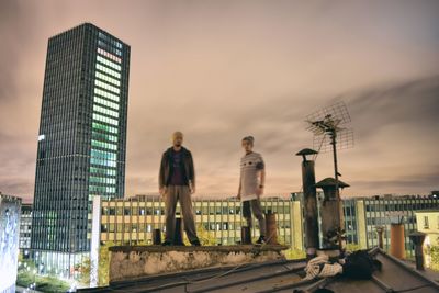 People in city against sky during sunset