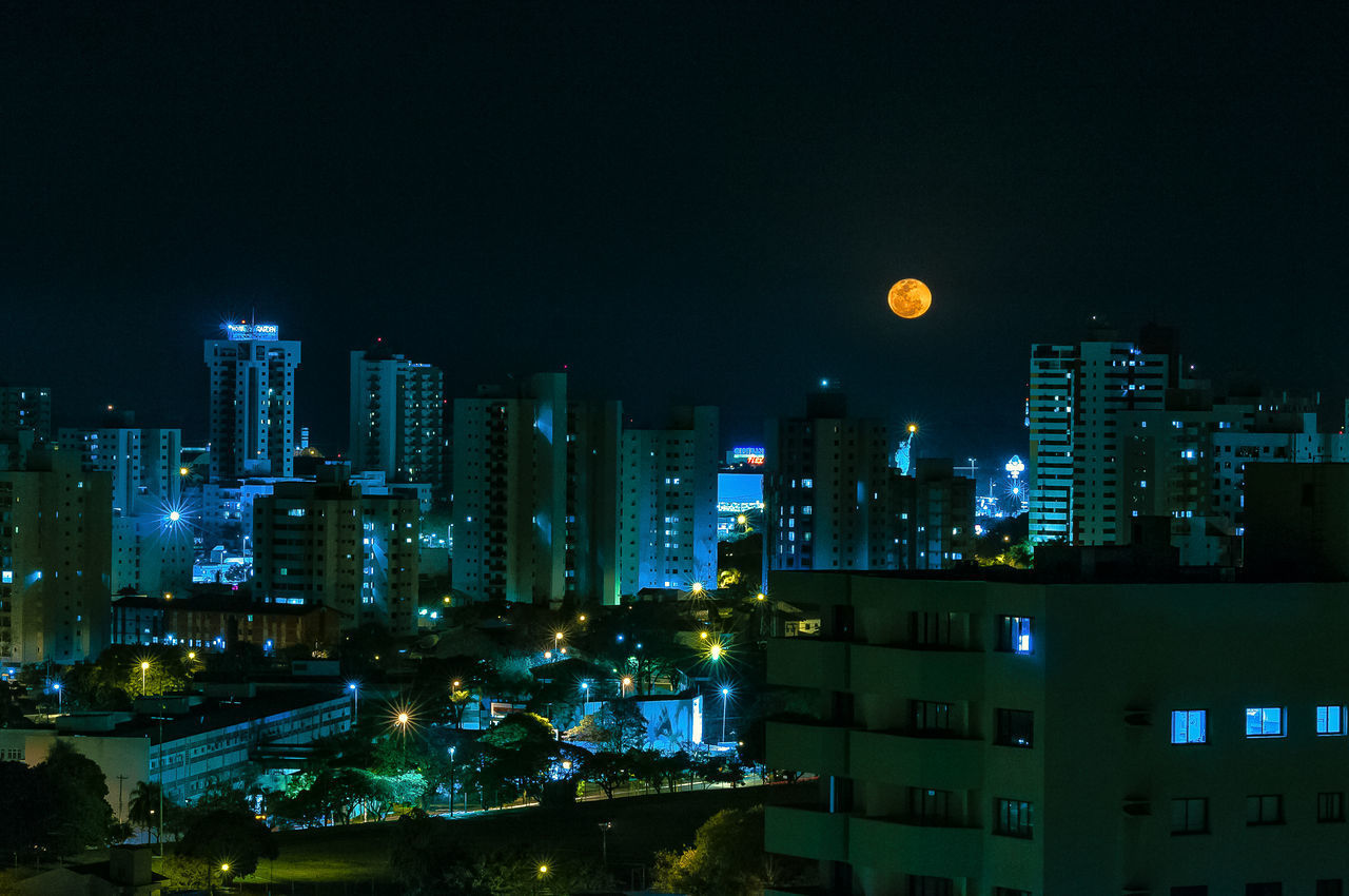 ILLUMINATED CITYSCAPE AGAINST SKY AT NIGHT