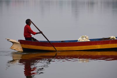 Reflection of man in boat on lake