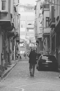 Rear view of woman walking on street in city