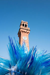 Low angle view of clock tower against blue sky