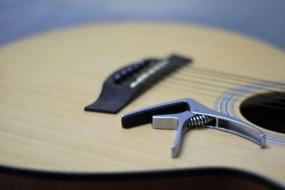 Guitar capo placed on acoustic guitar.