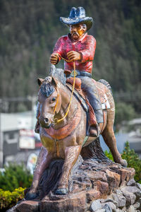 Cowboy riding horse statue