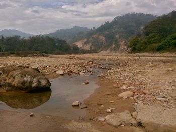 Scenic view of stream by lake against sky
