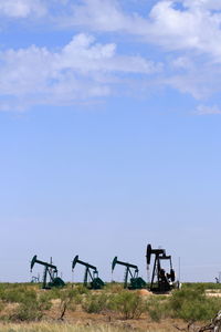 Windmills on field against sky