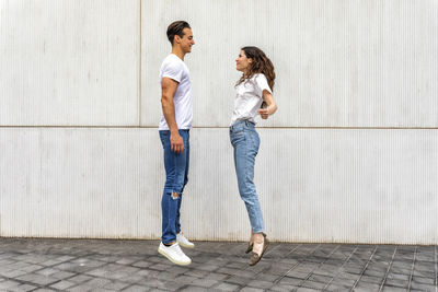 Young couple levitating by wall