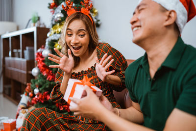 Portrait of young woman holding christmas tree