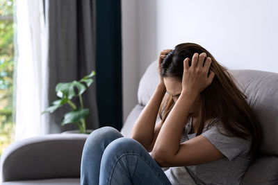 Rear view of woman sitting at home