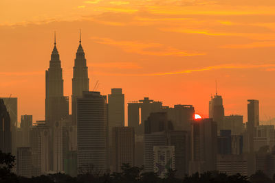 Modern buildings against sky during sunset