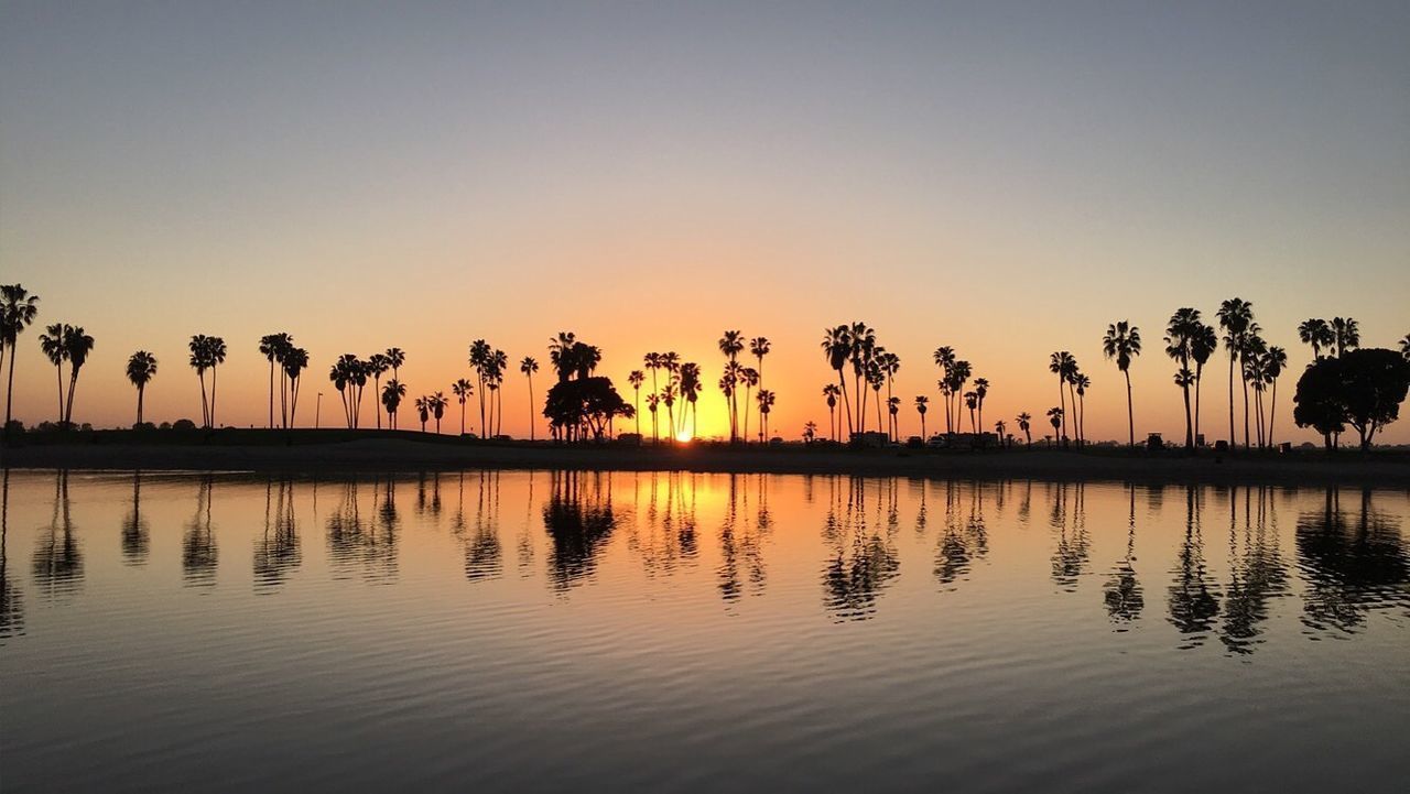 SILHOUETTE TREES BY LAKE AGAINST SKY DURING SUNSET