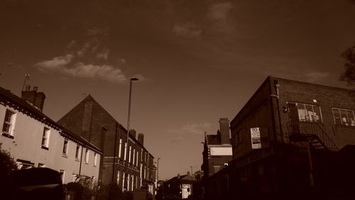 Low angle view of silhouette buildings against sky